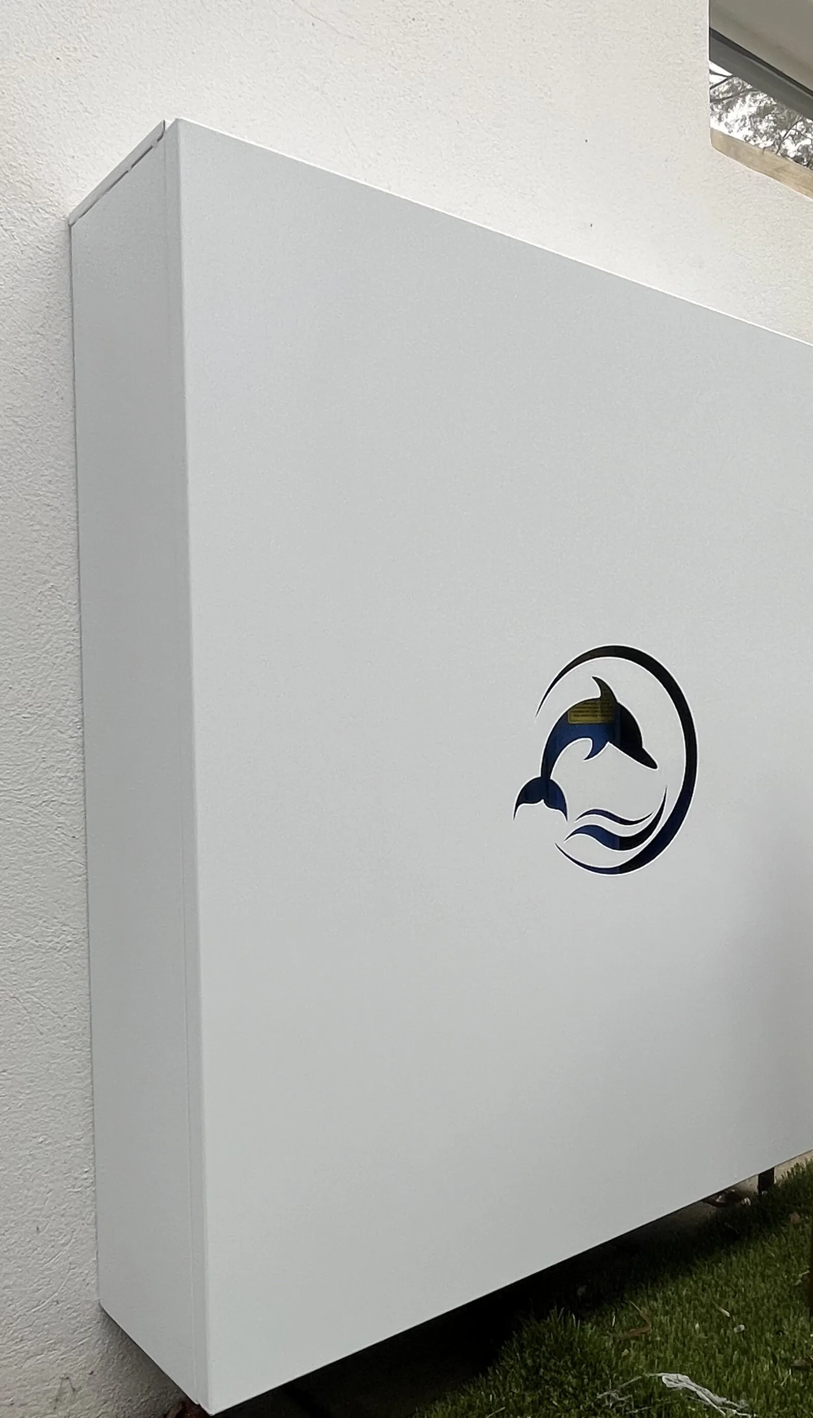 A white powdercoated Dolphin enclosure installed against a rendered wall