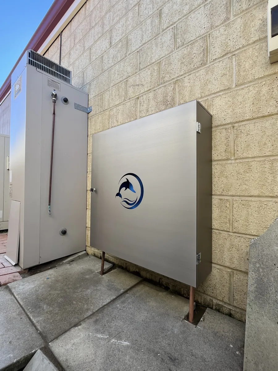 Stainless steel Dolphin enclosure installed beside a hot water system