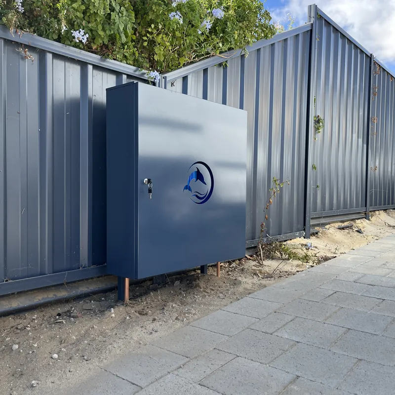 Navy powdercoated Dolphin enclosure installed against a steel fence
