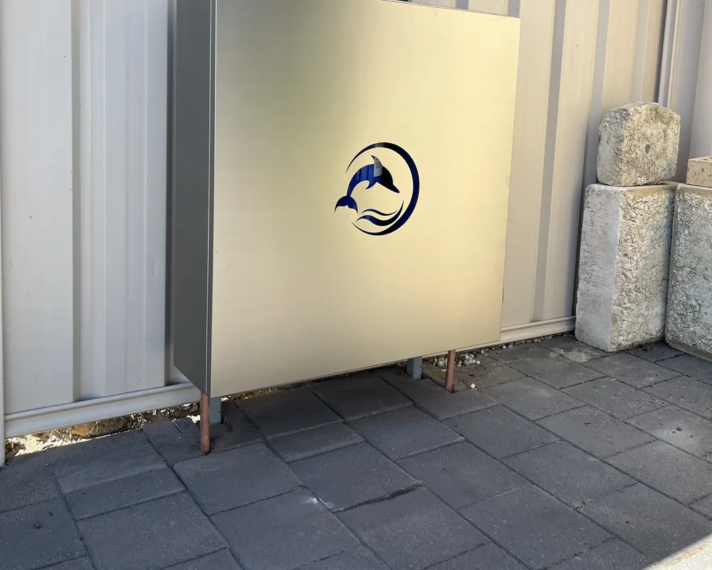 Stainless steel Dolphin enclosure installed against a boundary fence