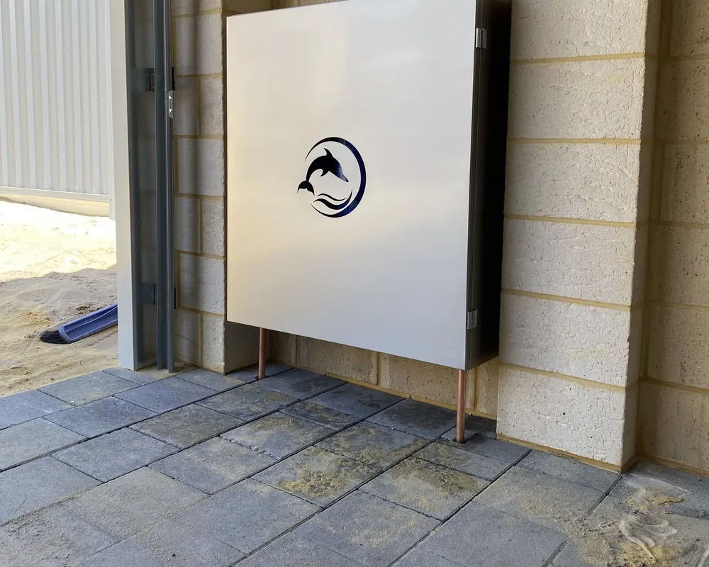 Stainless steel Dolphin enclosure installed against a limestone block wall