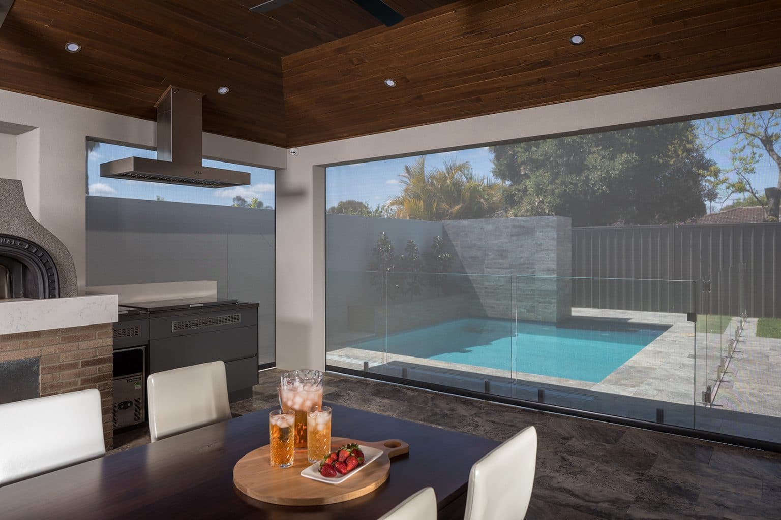 Outdoor alfresco area with a roller blind and pool